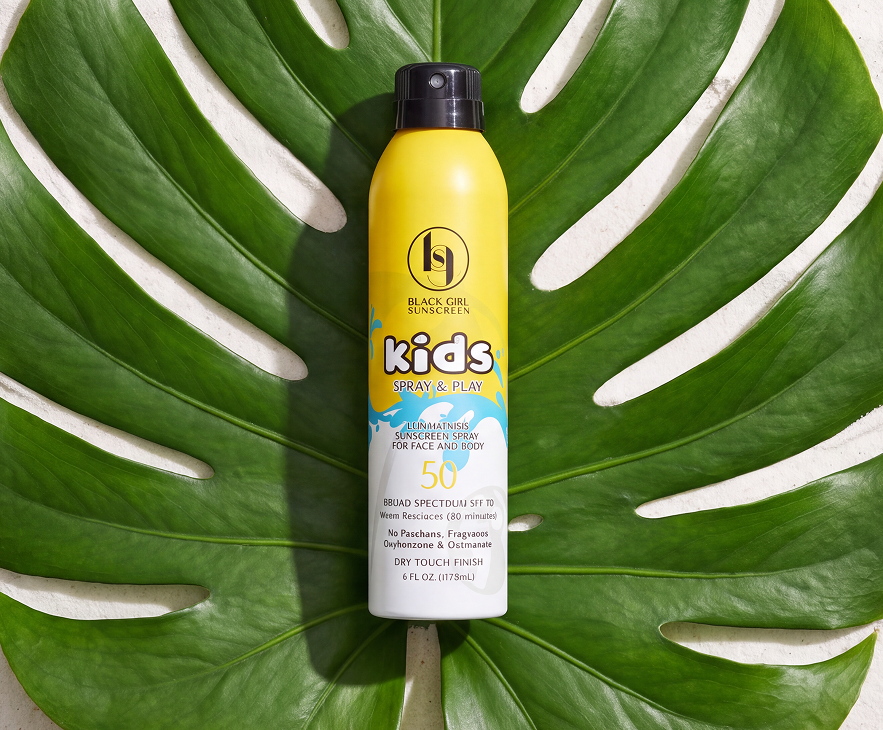 Black Girl Sunscreen Kids SPF 50 spray packaging on a tropical leaf